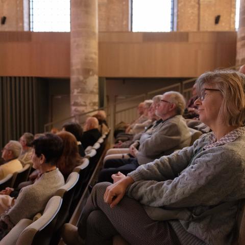 Verschillende vrijwilligers kijken aandachtig toe tijdens de presentaties op de nieuwjaarsreceptie.