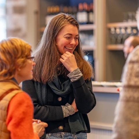 Medewerker Museum Hof van Busleyden lacht terwijl ze met vrijwilligers in gesprek is.